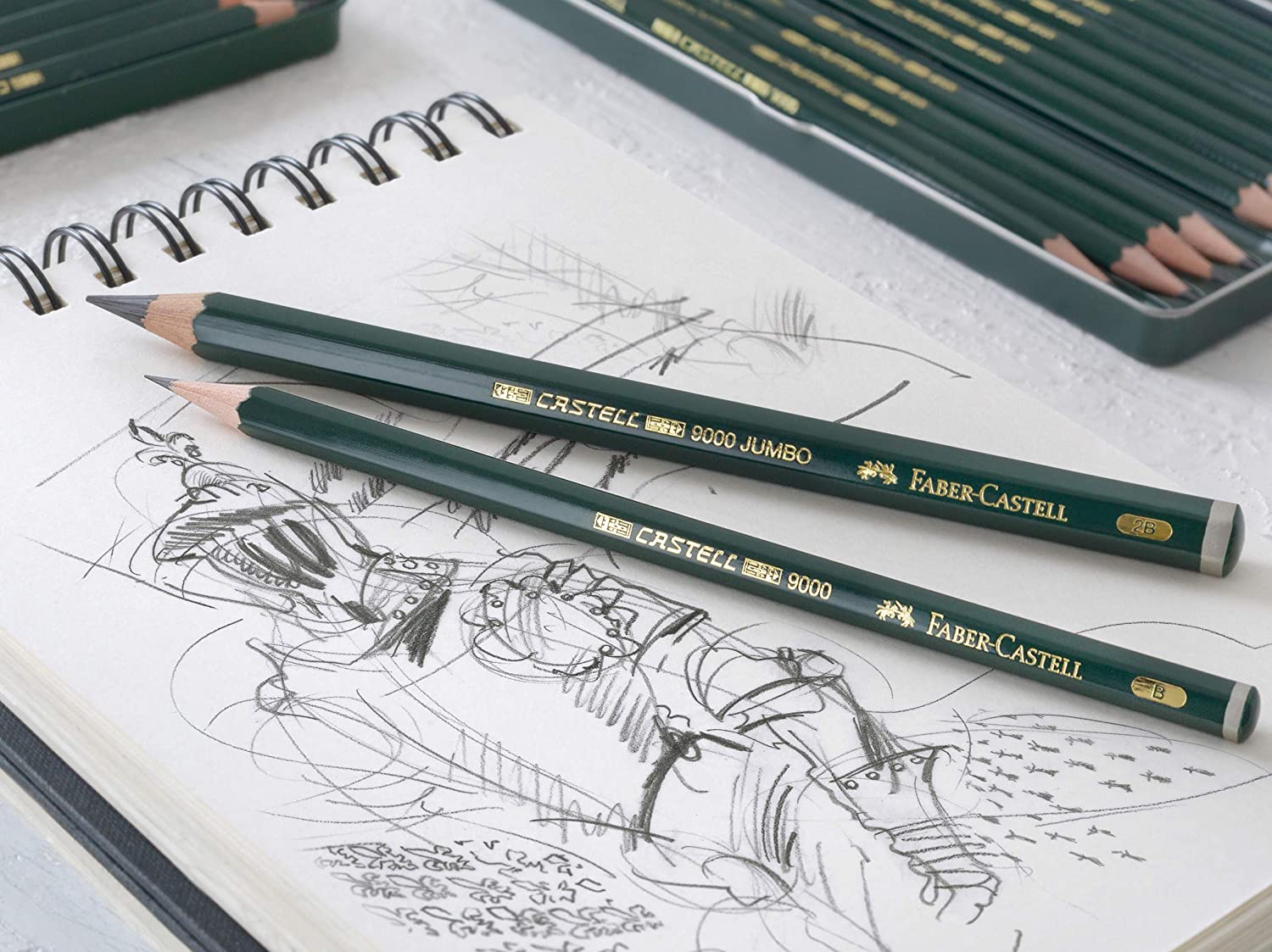 Faber-Castell 9000 Jumbo graphite pencil beside a standard Castell 9000 pencil over a sketchbook drawing