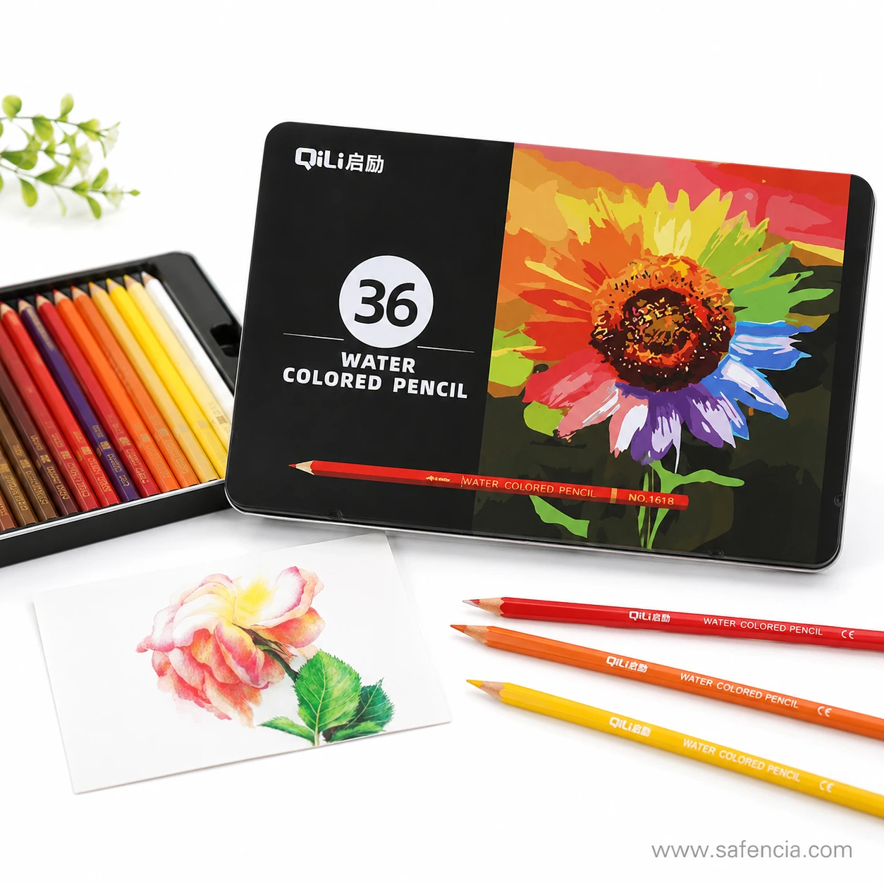 QiLi watercolour pencils tin standing open beside a painted flower card and loose pencils on a white surface
