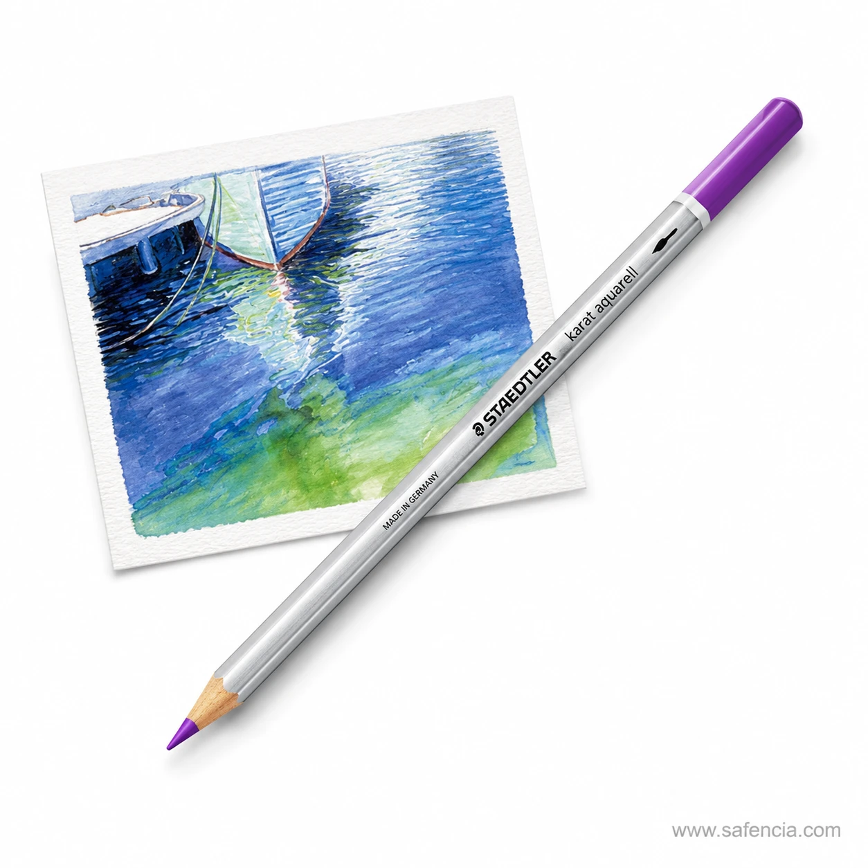 Staedtler Karat Aquarell watercolour pencil in purple lying beside a washed seascape study with a sailing boat