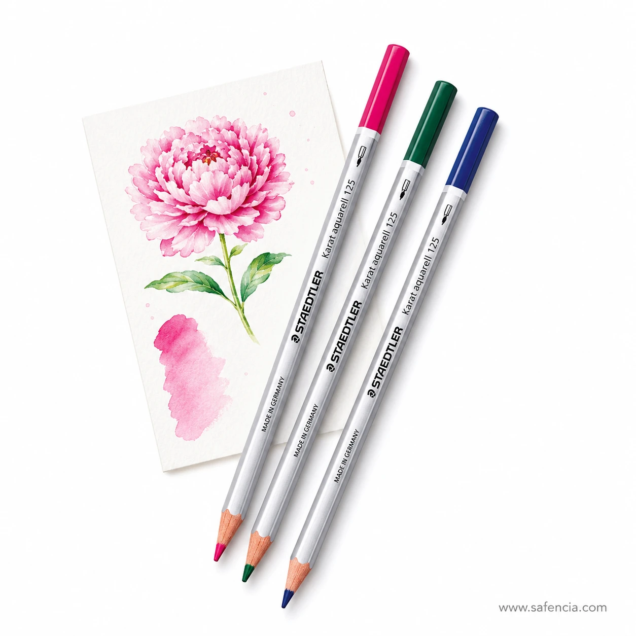 Three Staedtler Karat Aquarell watercolour pencils in pink, green and blue laid across a painted peony card