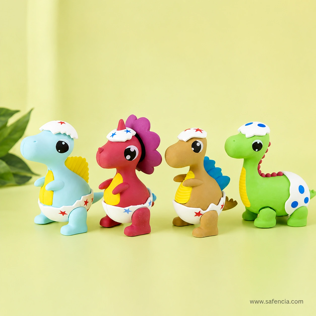 Line-up of the blue, red, brown and green baby dinosaur erasers viewed side on, showing each hatching-egg design in full