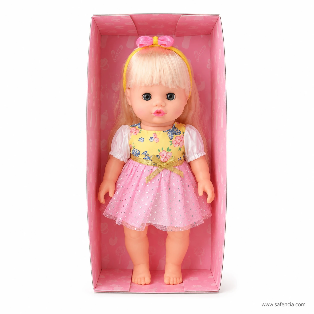 Blonde musical baby doll standing in the open pink moulded tray with the box lid removed