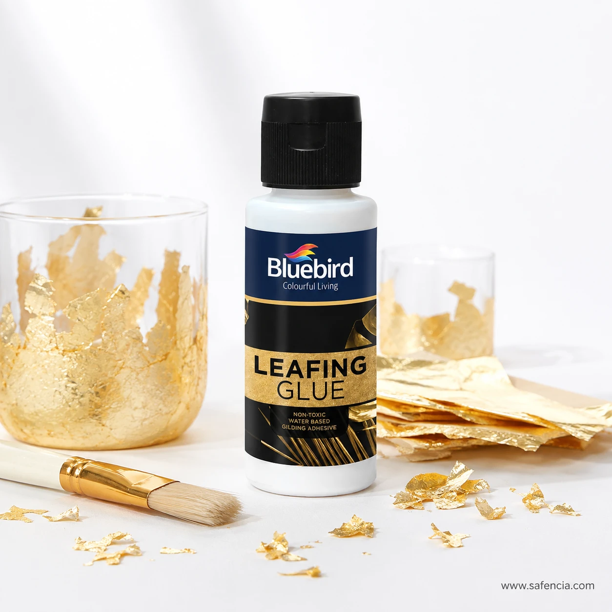 Bluebird Leafing Glue 100 mL bottle angled view on white background with scattered gold flakes and brush