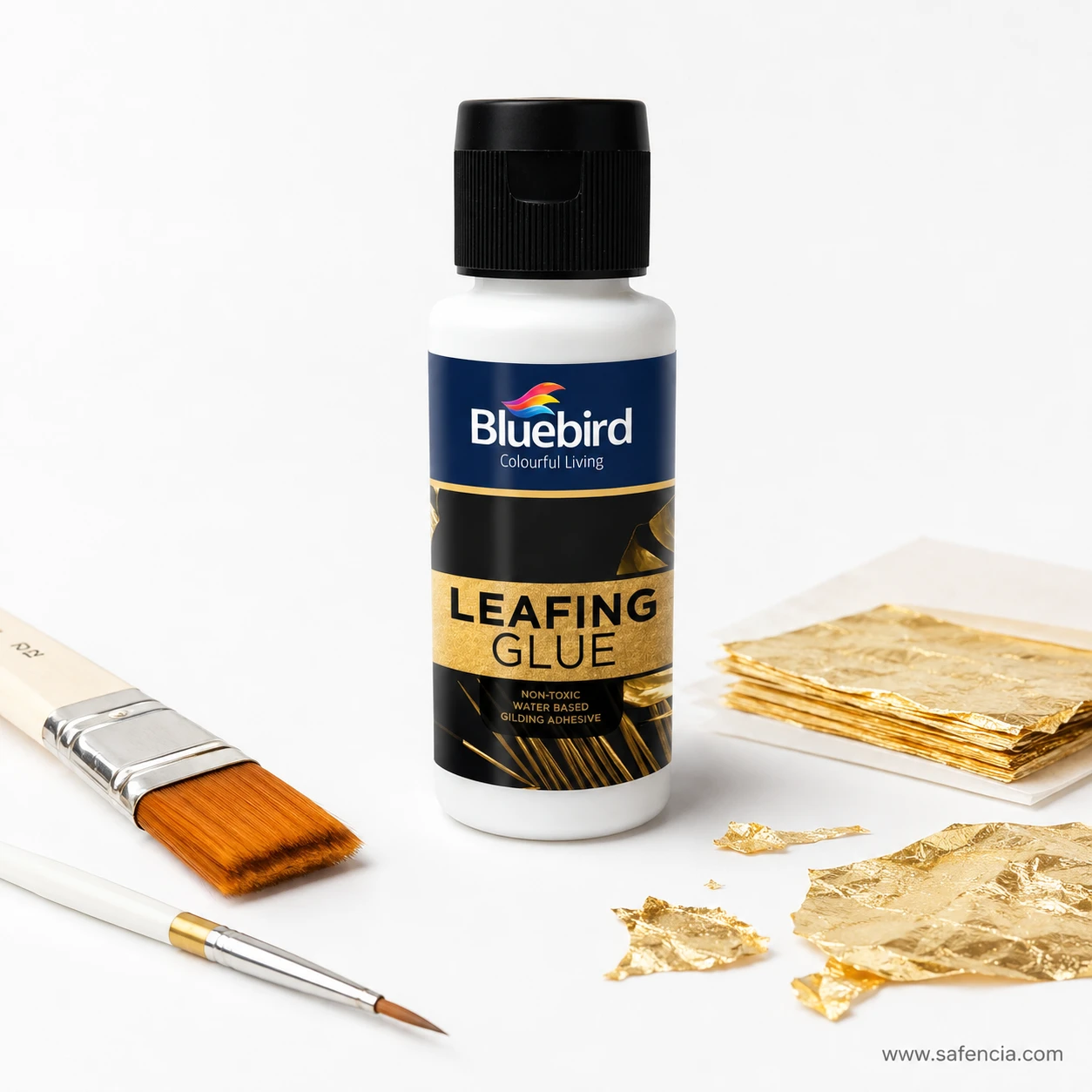 Bluebird Leafing Glue bottle arranged with synthetic gilding brushes and sheets of gold foil leaf