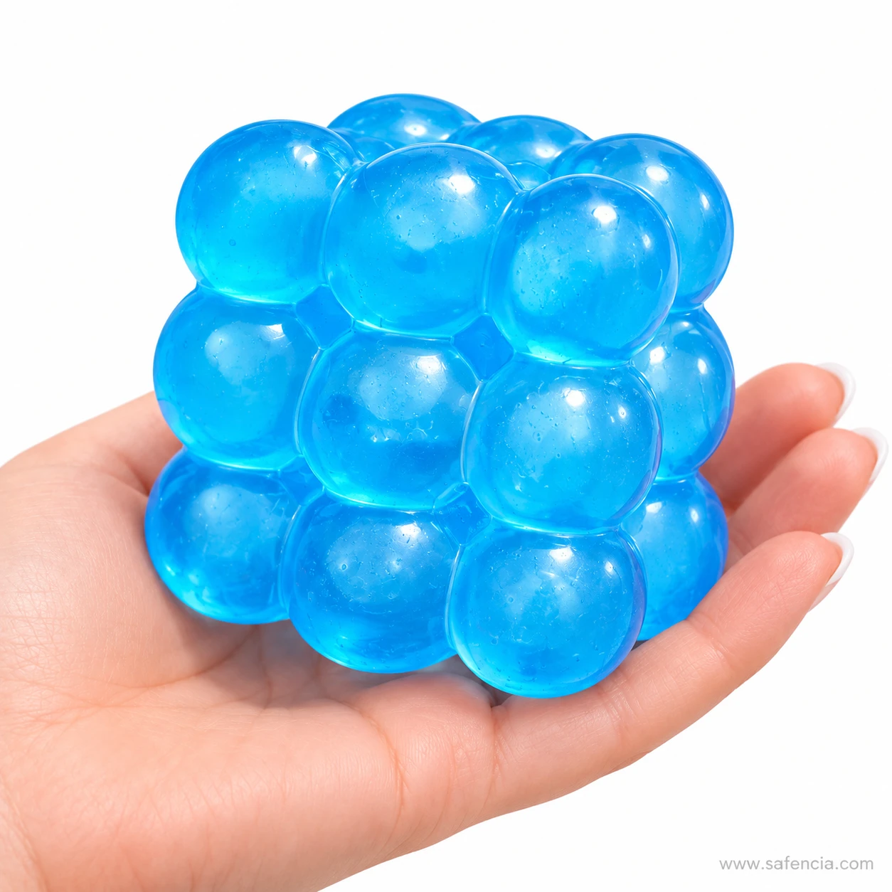 Blue bubble squishy cube resting on an open palm to show its 5 cm size