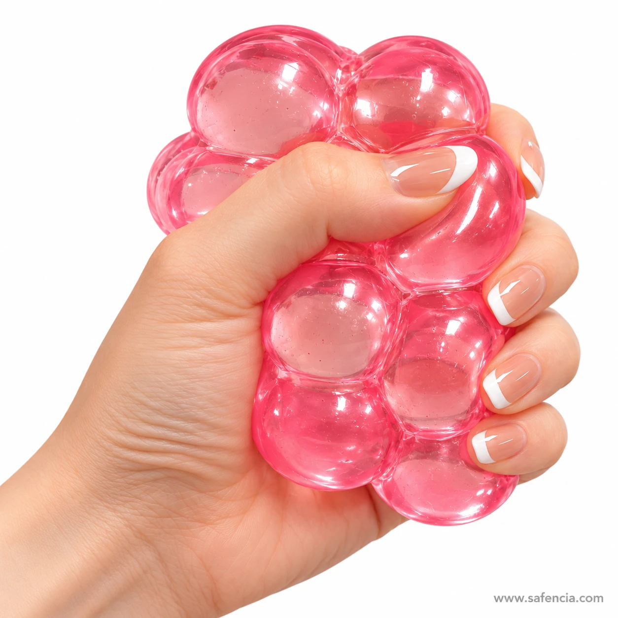 Hand squeezing a pink bubble squishy cube so the rounded bubbles swell between the fingers