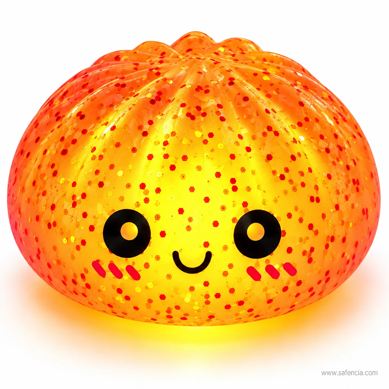 Close view of a glowing orange bun squishy night light showing its pleats, glitter flecks and smiling face