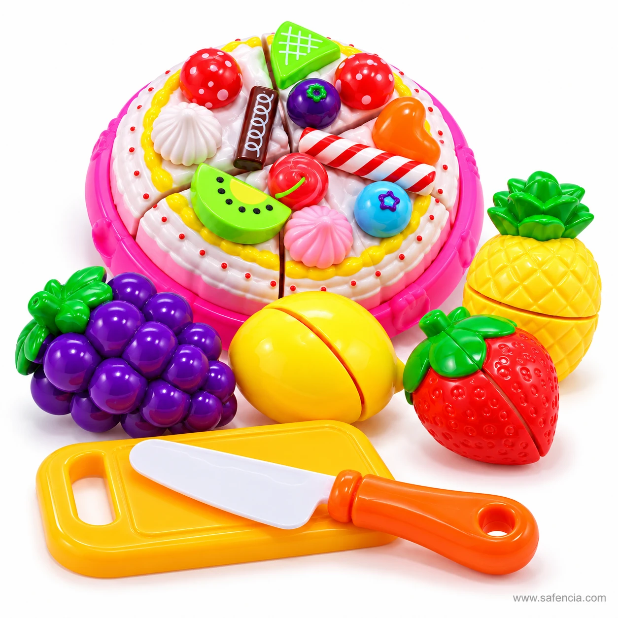 Whole decorated toy cake with grapes, lemon, strawberry and pineapple beside a yellow chopping board and knife