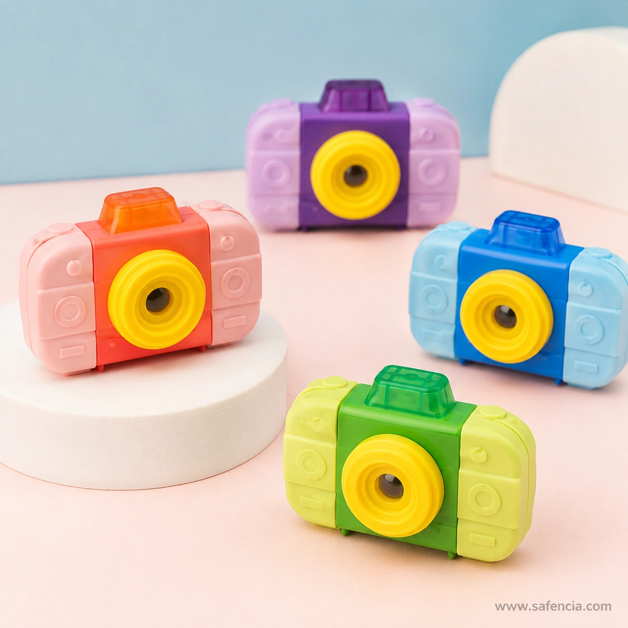 Camera eraser sharpeners arranged on pink and blue backgrounds showing the two-tone bodies and matte eraser side panels