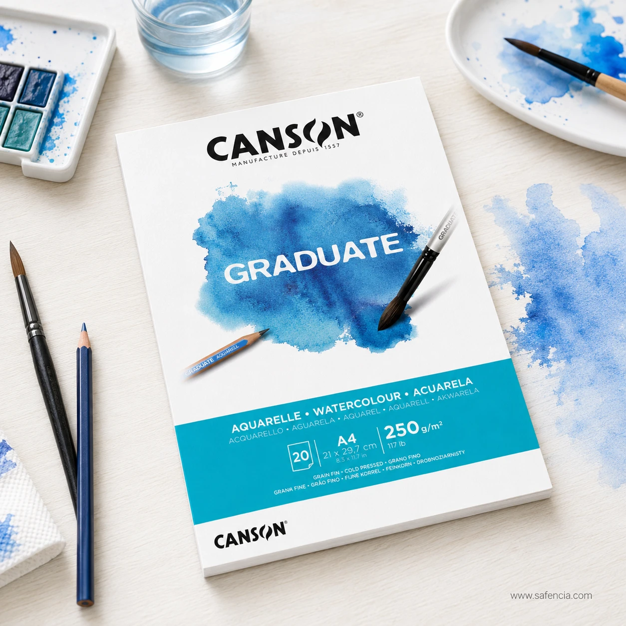 Canson Graduate watercolor pad on art studio workspace with paints and brushes