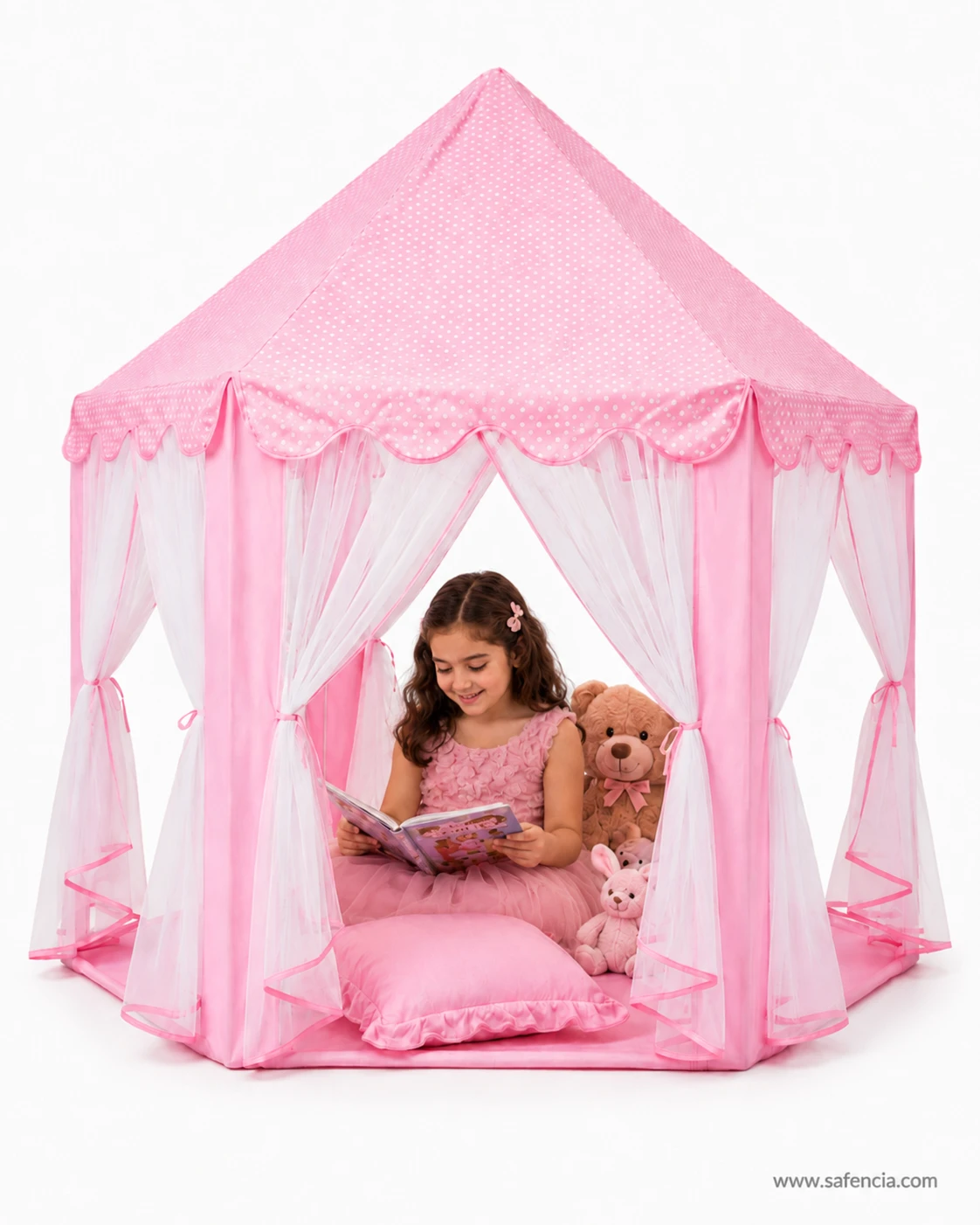 Girl sitting inside the pink princess castle tent house reading a book with soft toys beside her