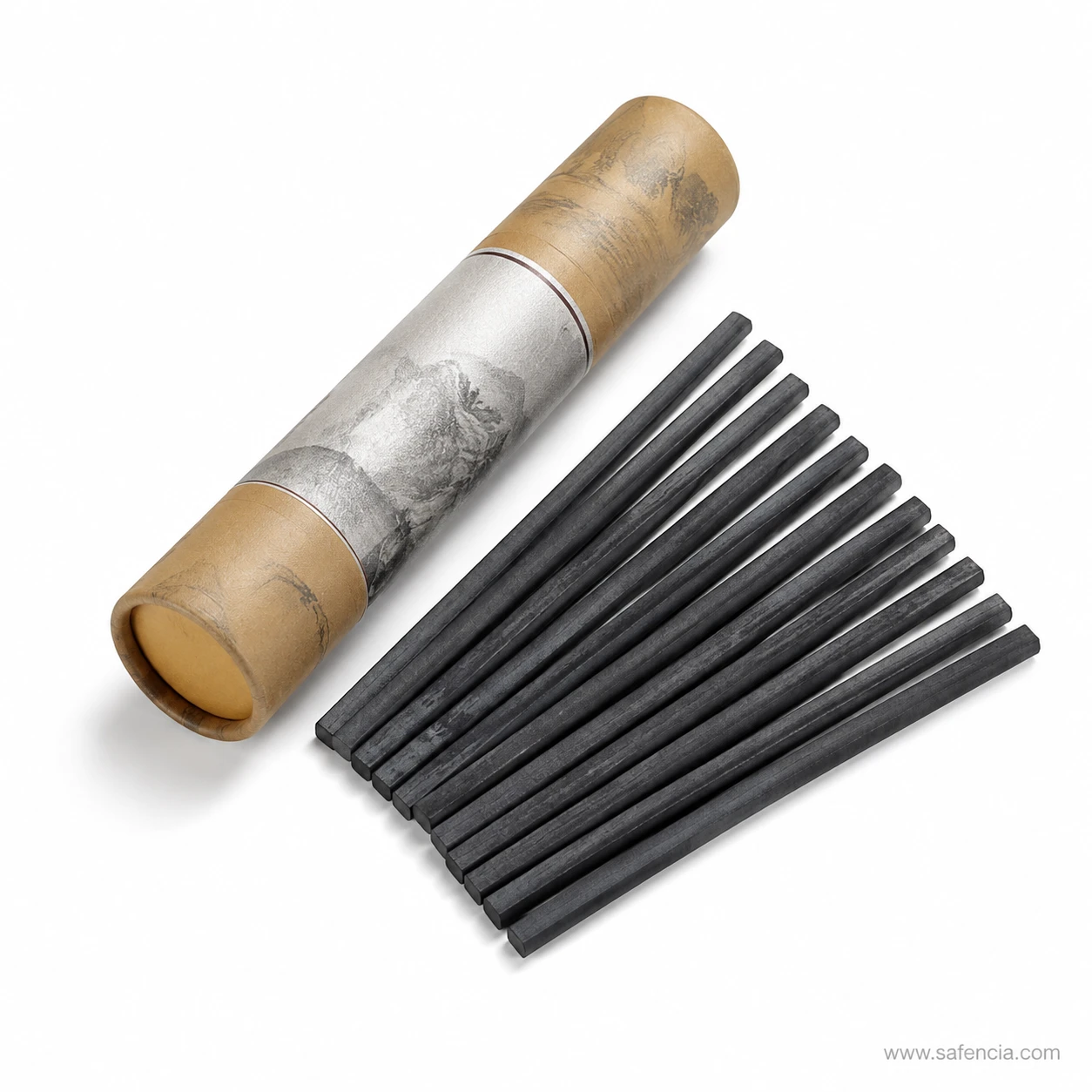 Square charcoal sticks fanned out in a row beside the closed paper tube