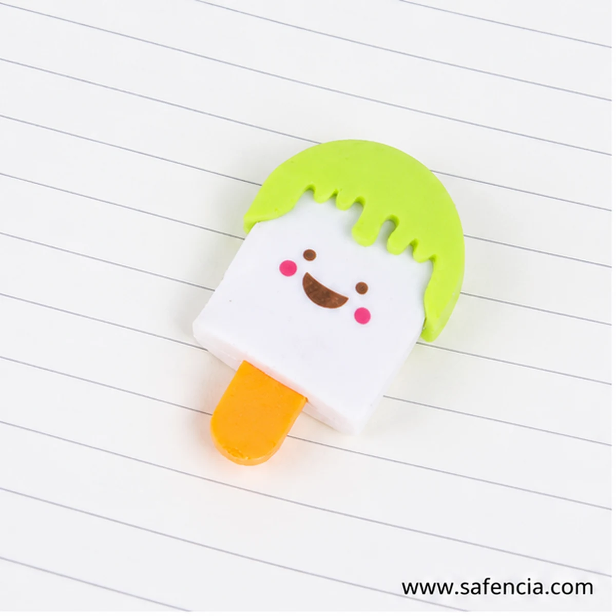 Single green-cap popsicle eraser with a smiling face lying on a ruled notebook page