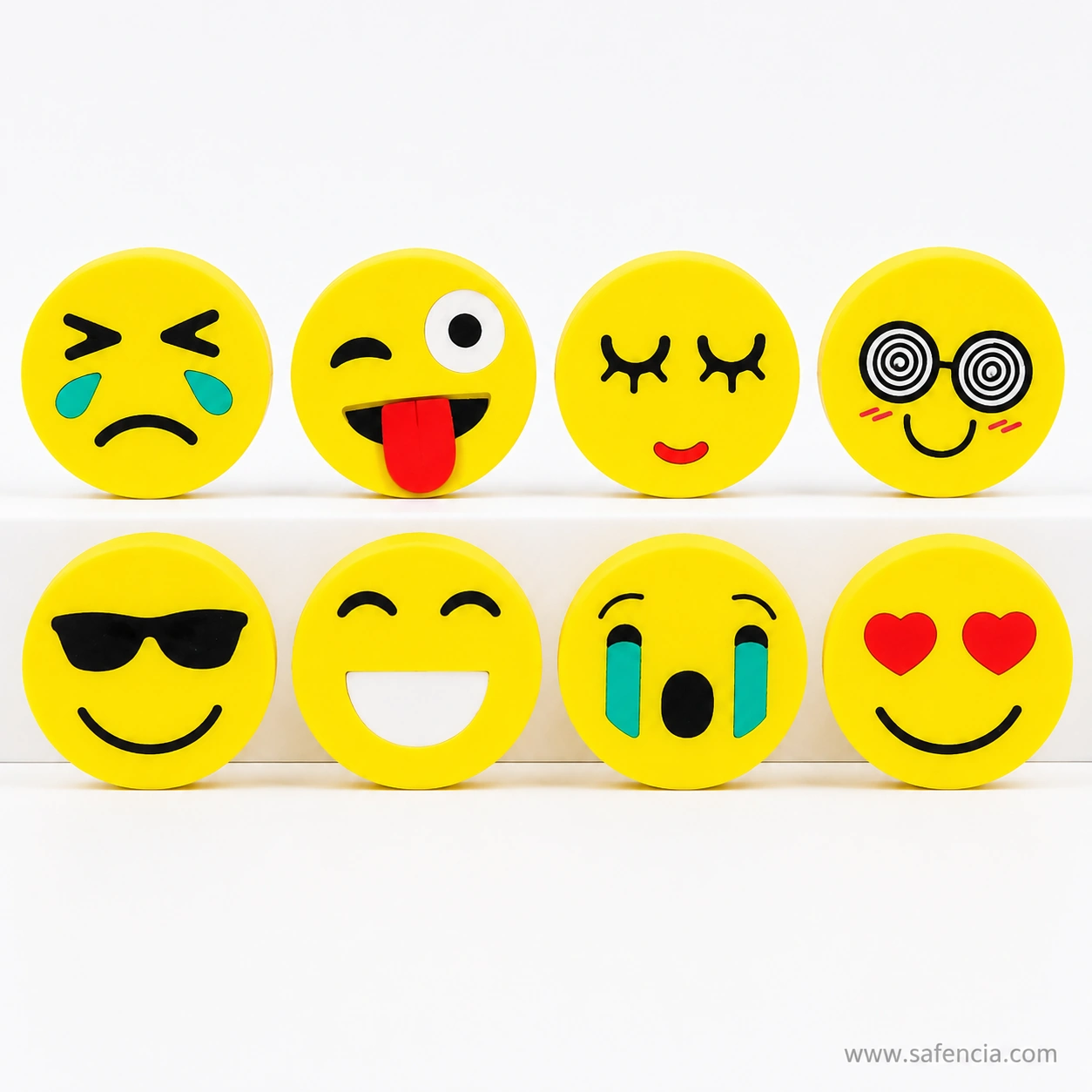 Eight emoji face erasers lined up in two rows showing crying, winking, sunglasses, heart eyes and closed-eye smile designs