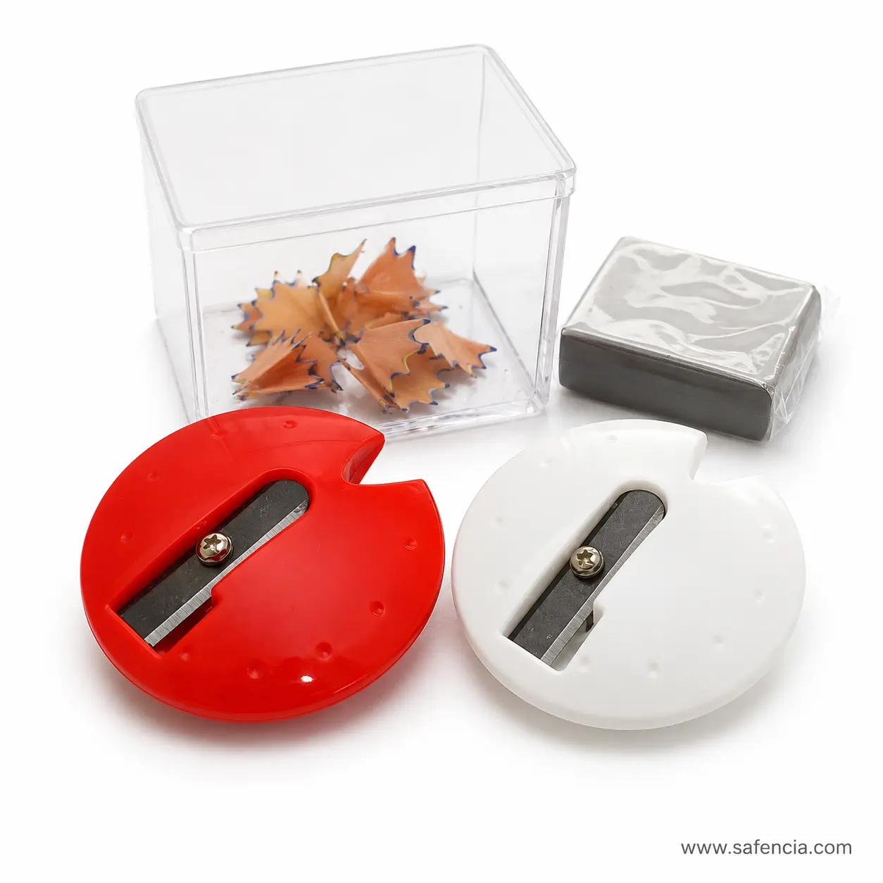 Red and white UFO pencil sharpeners with round bodies beside clear box of pencil shavings