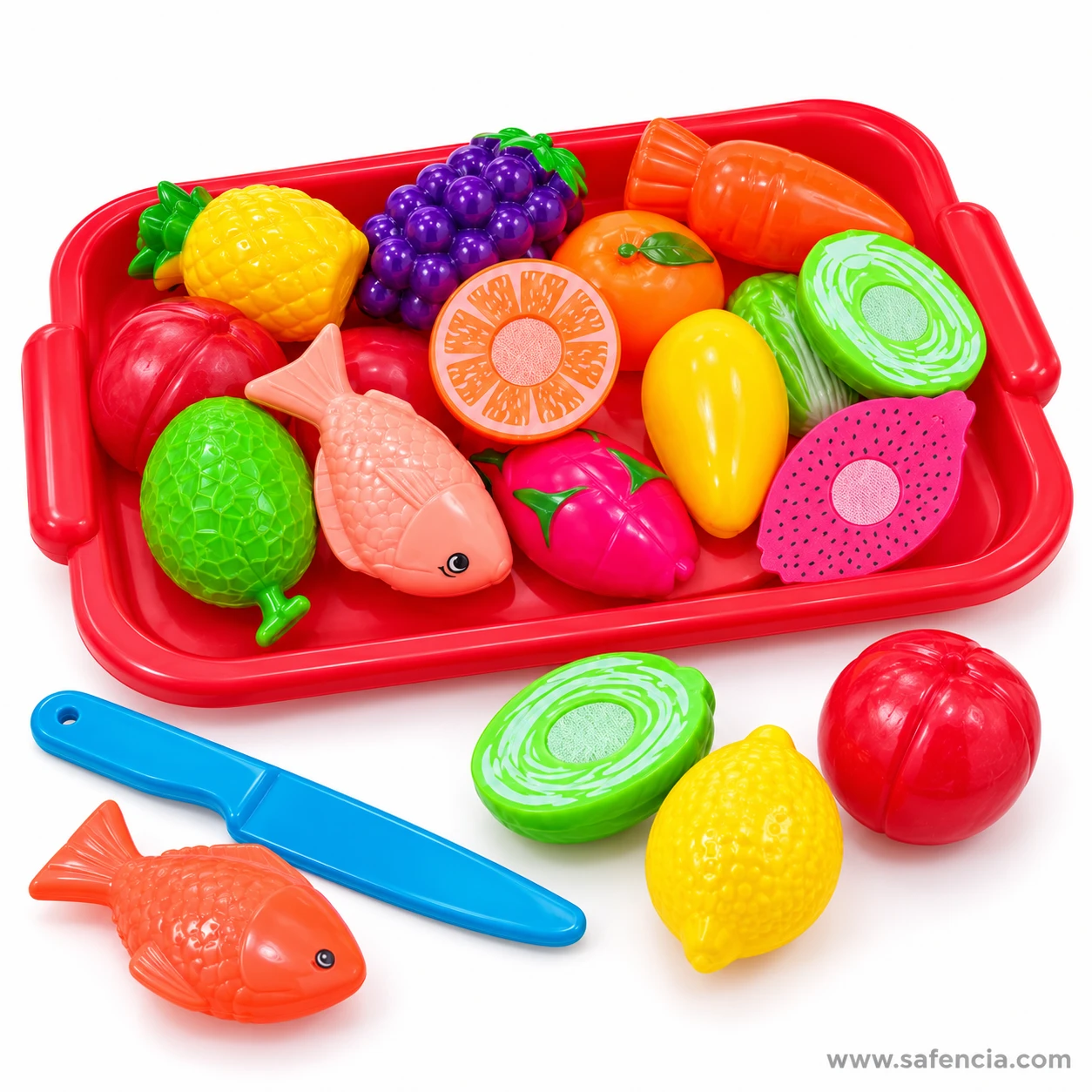 Toy fish, lemon-yellow mango, cabbage half and red apple beside the blue knife and the fruit tray