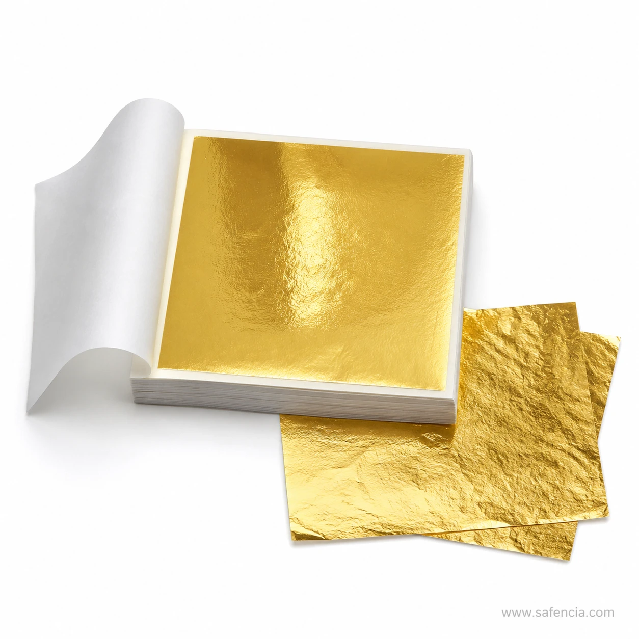 Loose gold leaf sheets lying beside the open gilding booklet