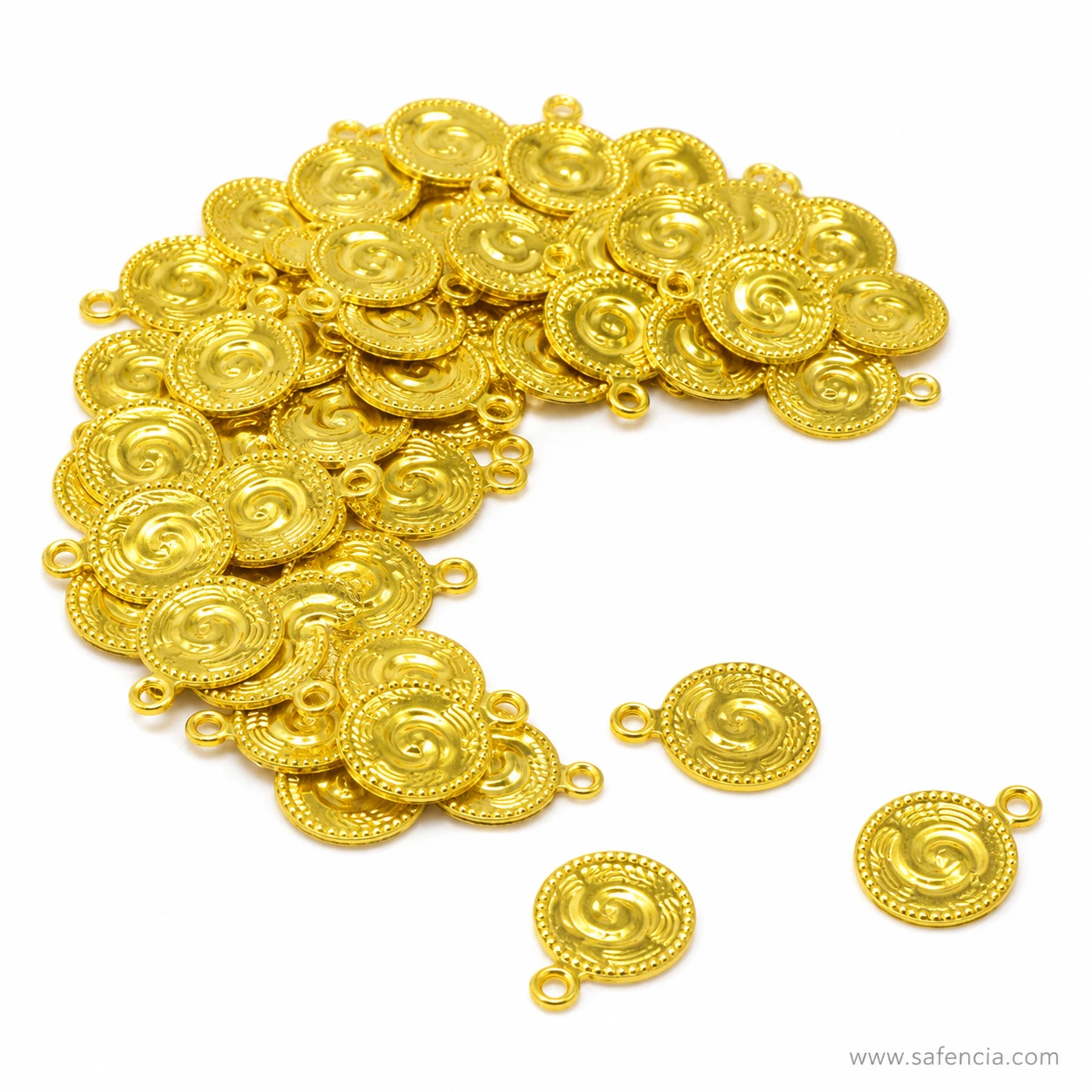 Close view of a pile of gold-tone swirl charm connectors showing the beaded rim detail
