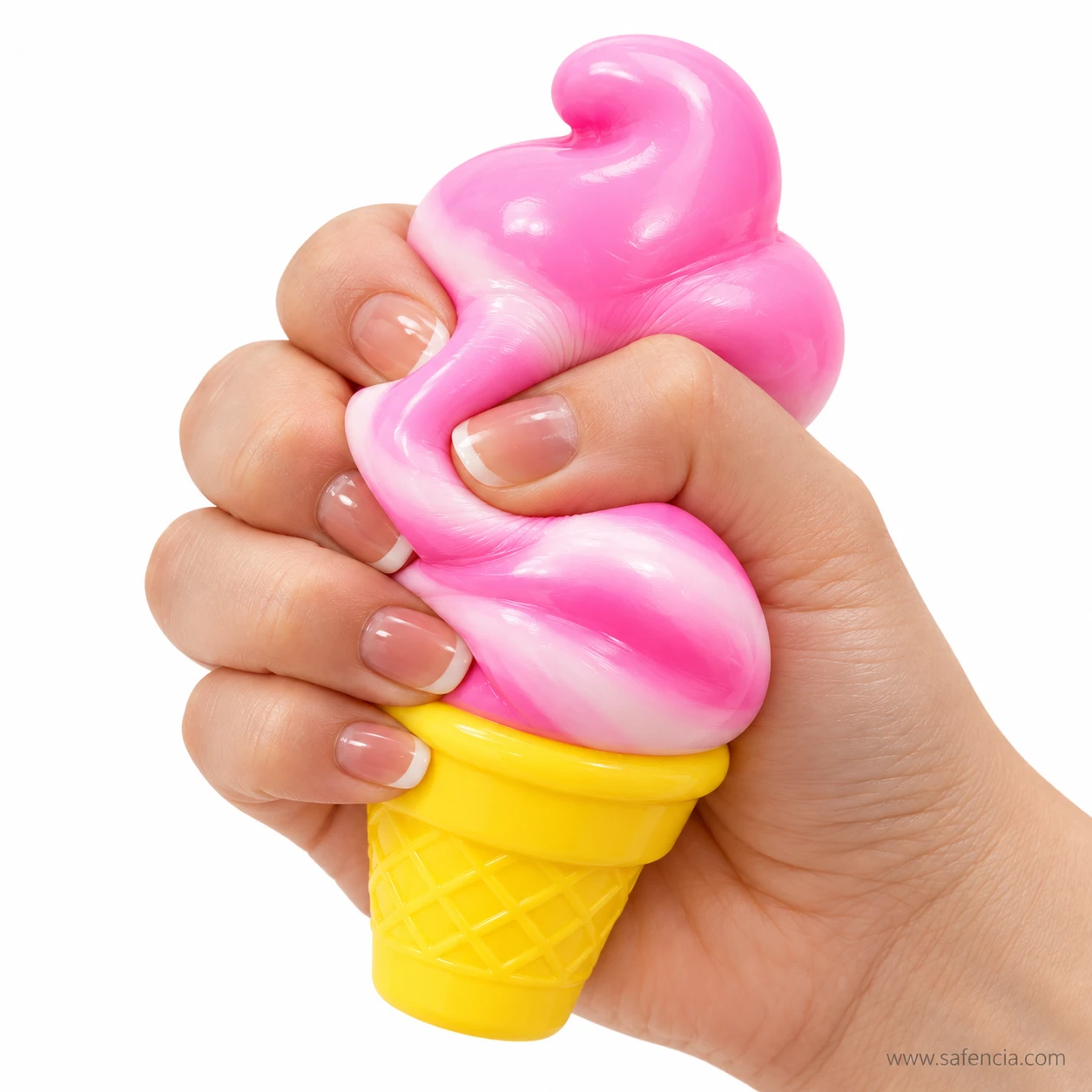 Hand squeezing the pink ice cream swirl of the cone squishy while holding the firm yellow cone
