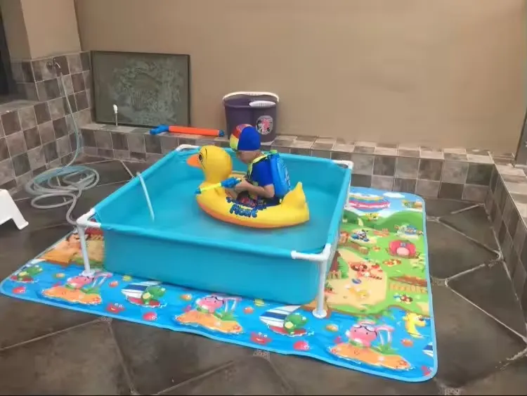 Intex Mini Frame Pool set up on a patio with a young child sitting inside using a duck float