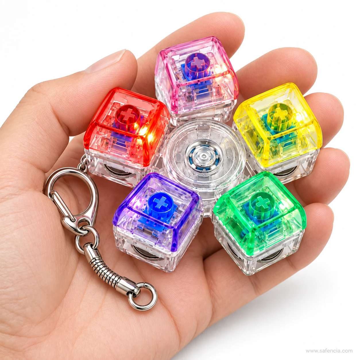 Five-key keyboard keychain fidget spinner lying flat in an open adult palm with its keychain