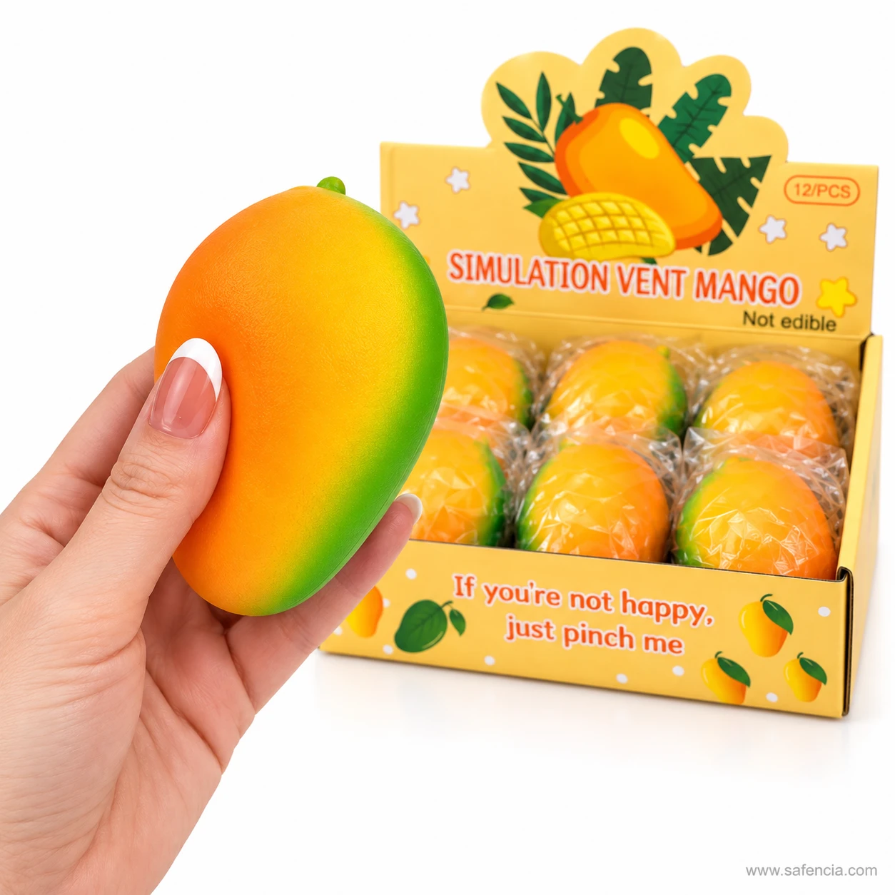 Hand holding a mango squishy beside the open display box of wrapped mangoes