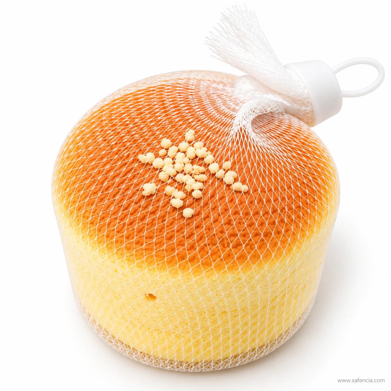 Front view of the mini sponge cake squishy showing the pale sponge side and baked top in its net