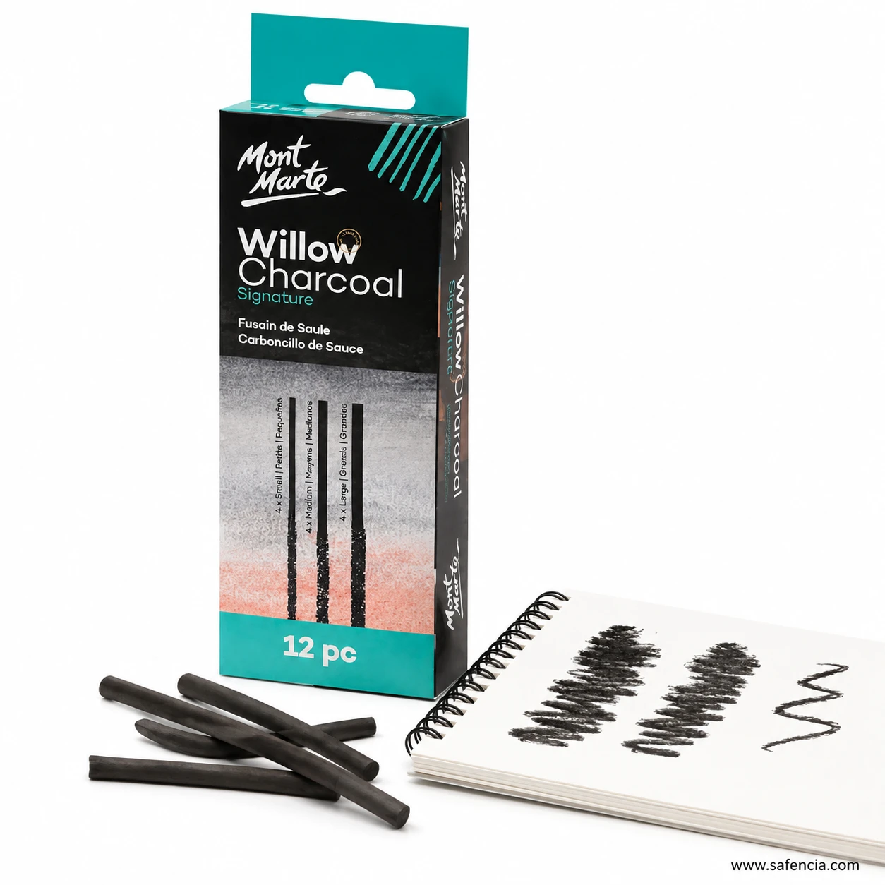 Willow charcoal box beside a sketchbook showing charcoal strokes on the page