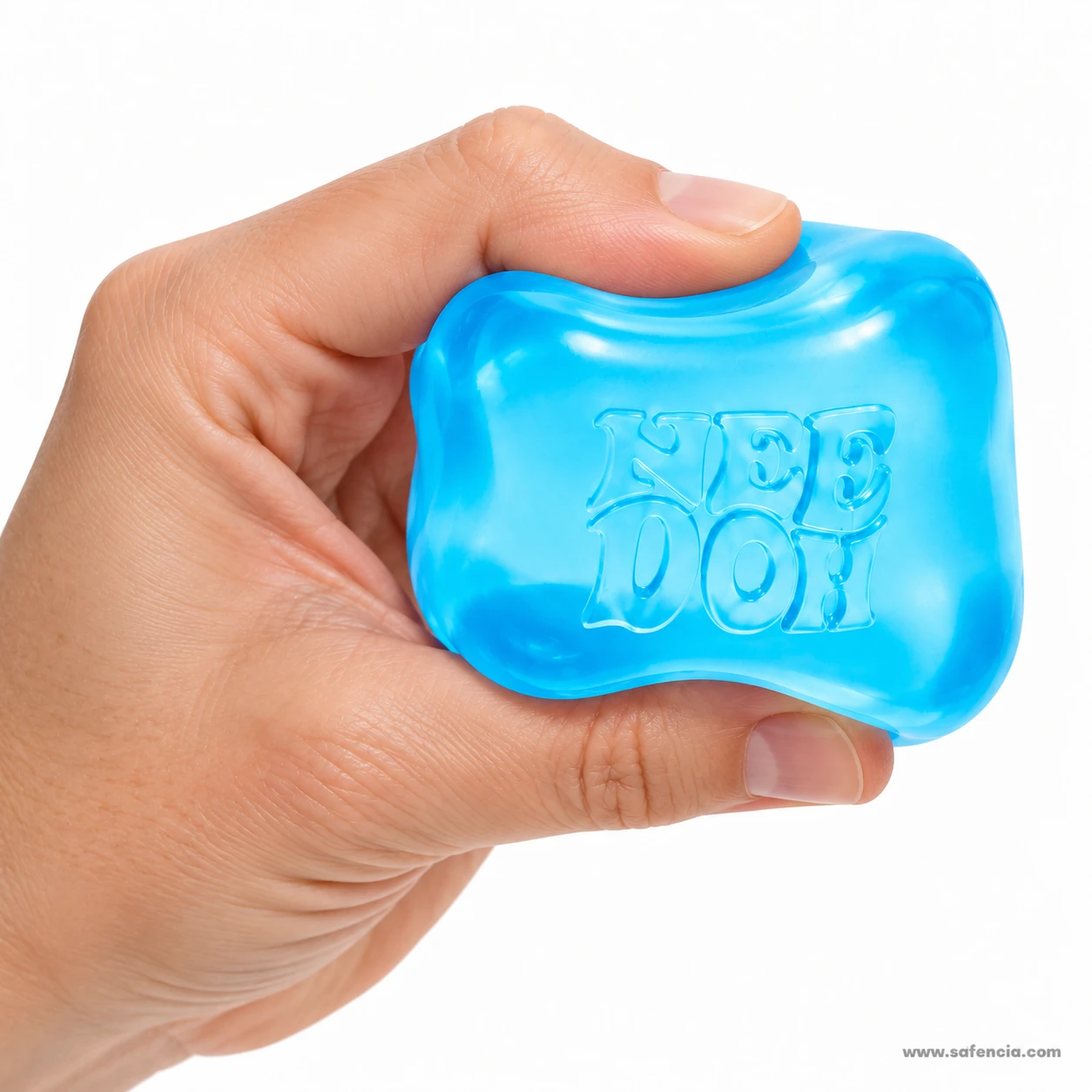 Hand pressing the blue nice cube squishy flat so the NEE DOH lettering stretches across the gel