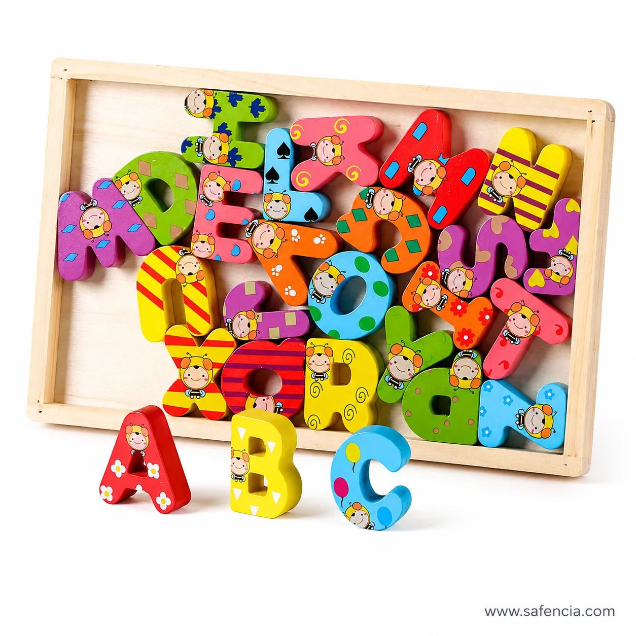 Wooden tray of chunky capital letters printed with cartoon faces flowers and stripes