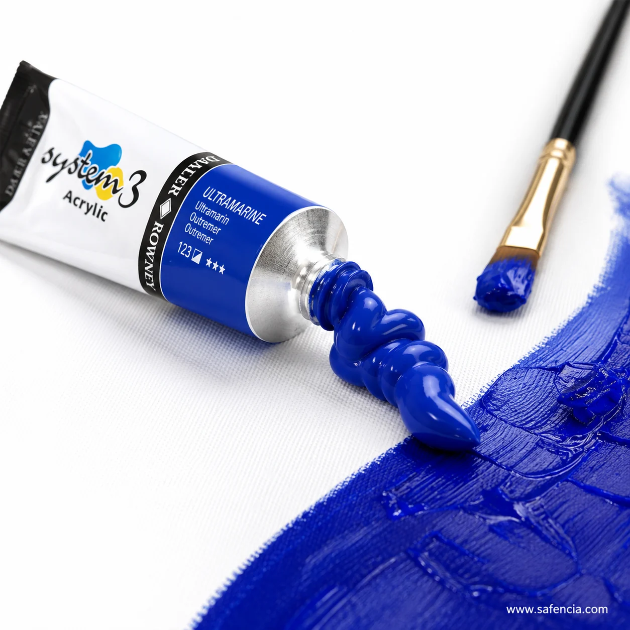 Daler-Rowney System 3 Ultramarine 123 tube squeezed onto thick blue paint beside a brush