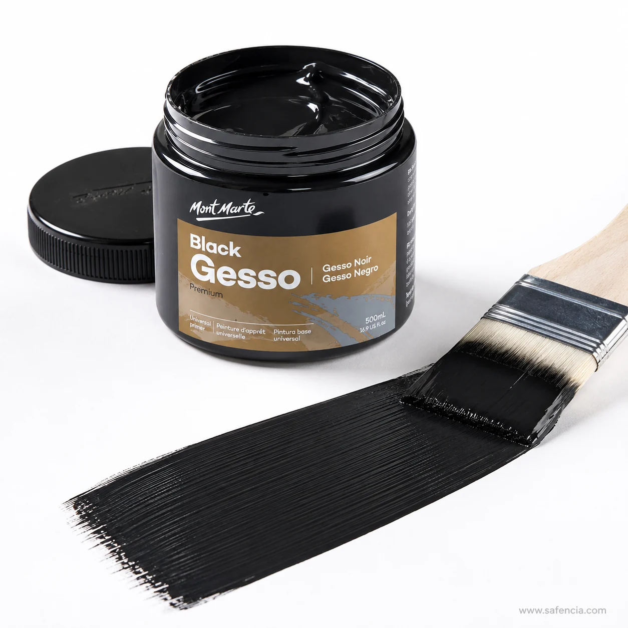 Wide brush laying a solid band of black gesso across a white board