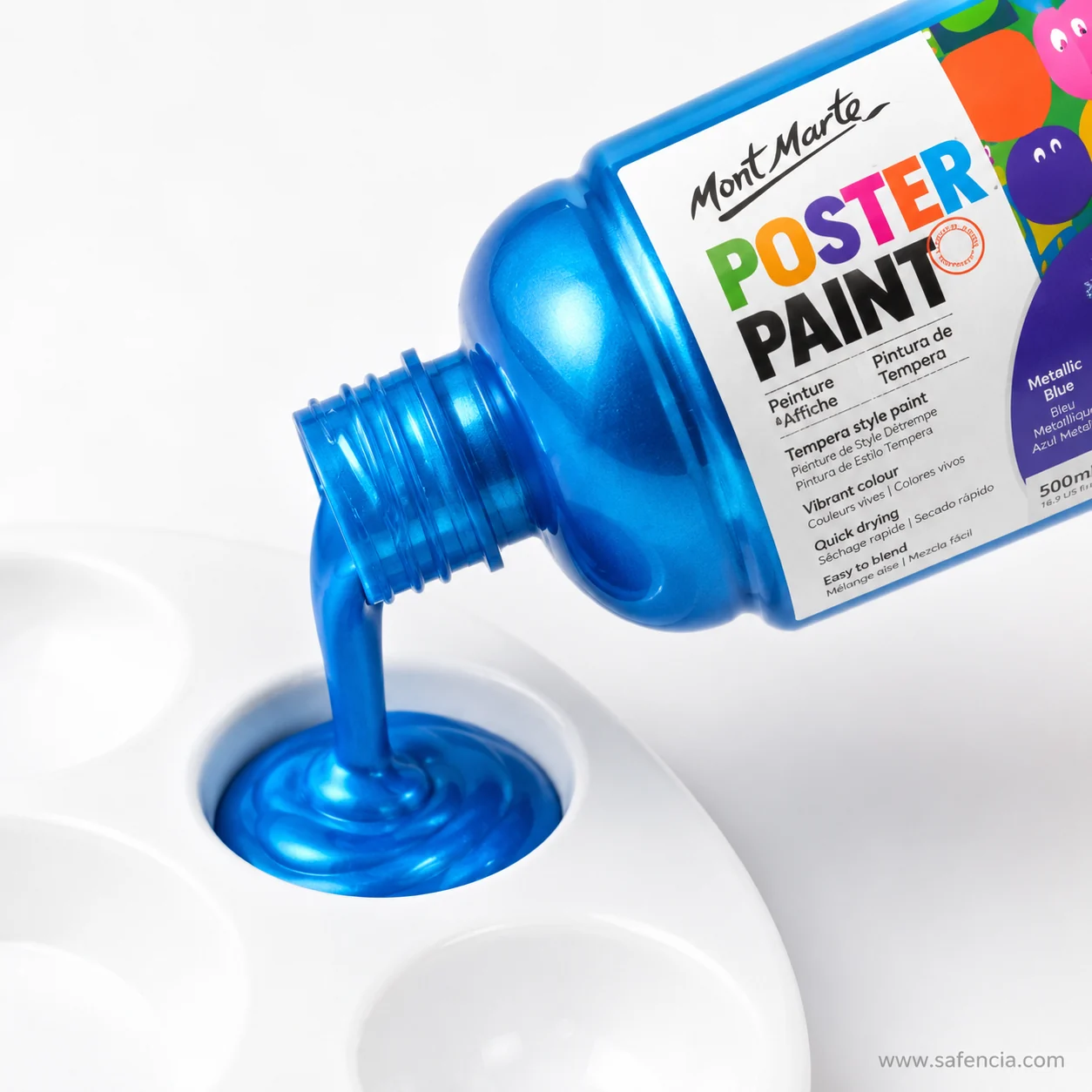Metallic blue poster paint pouring from a tipped bottle into a white dish