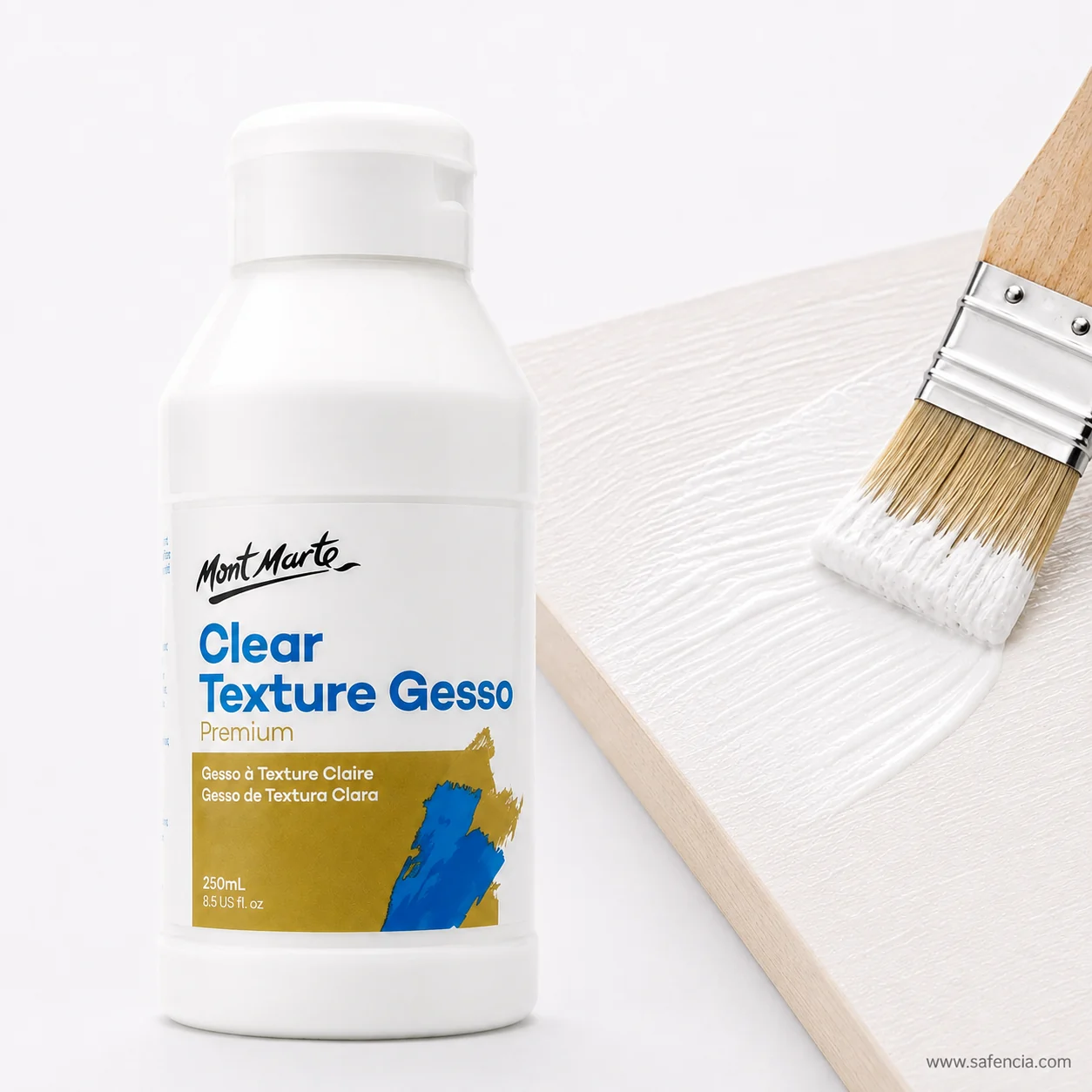 Wide flat brush laying clear texture gesso across a pale board leaving brush ridges
