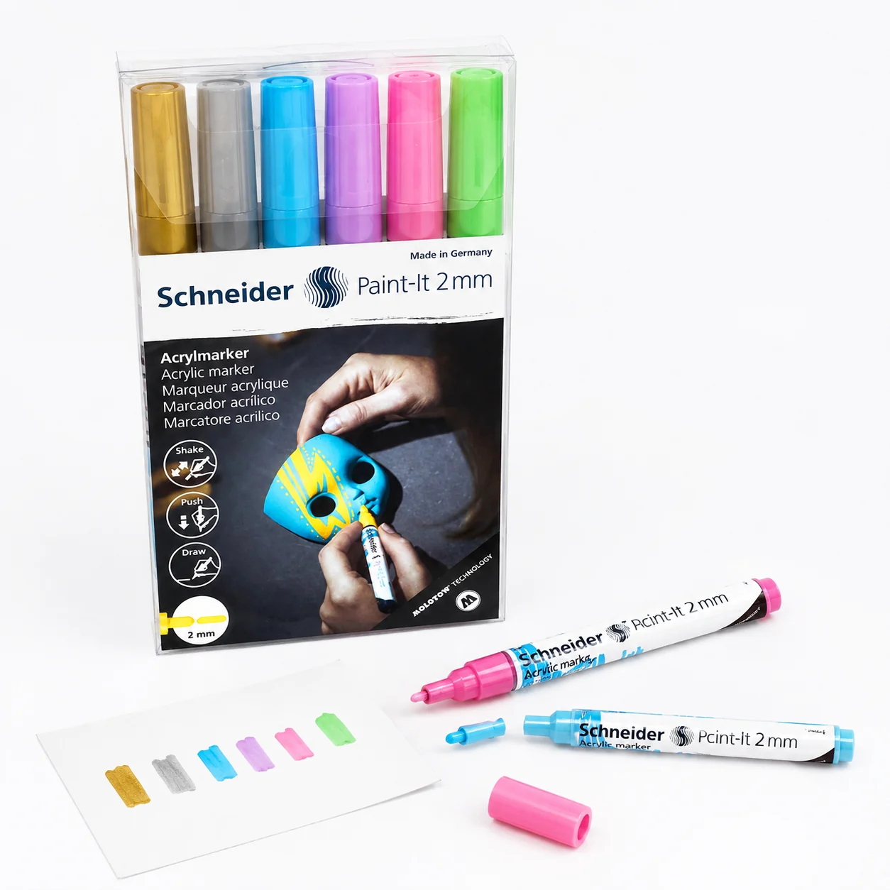 All six Schneider Paint-It marker colours swatched in a row on white paper beside two uncapped pens