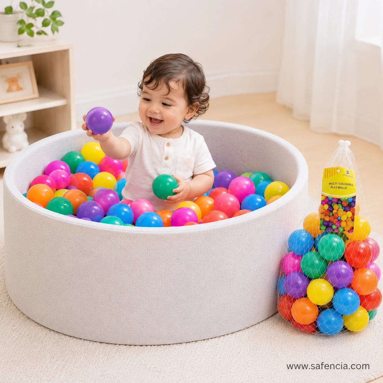 Happy baby toddler playing inside a soft-sided round ball pit filled with colorful plastic play balls