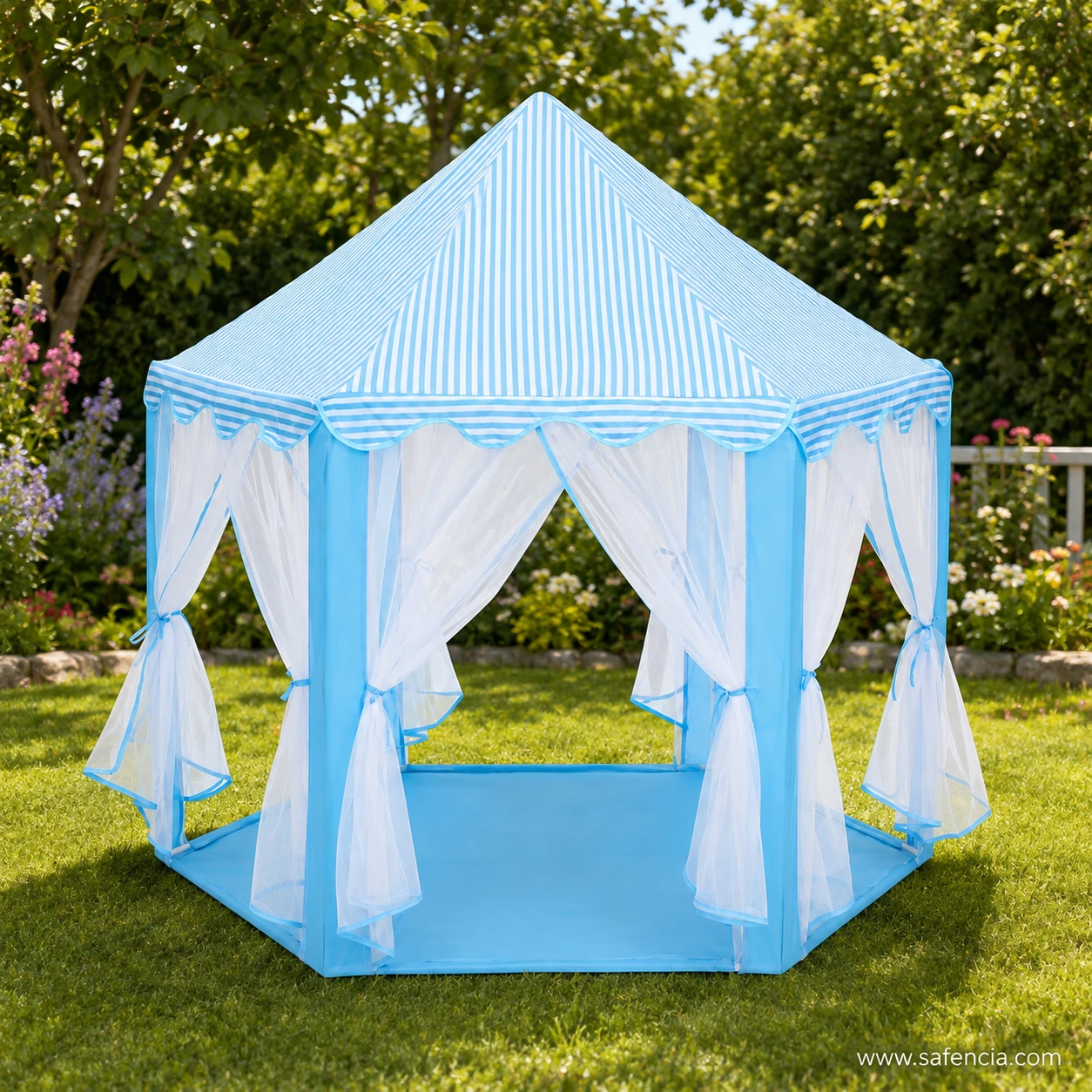 Blue castle play tent house standing on a lawn in a garden with net curtains hanging loose