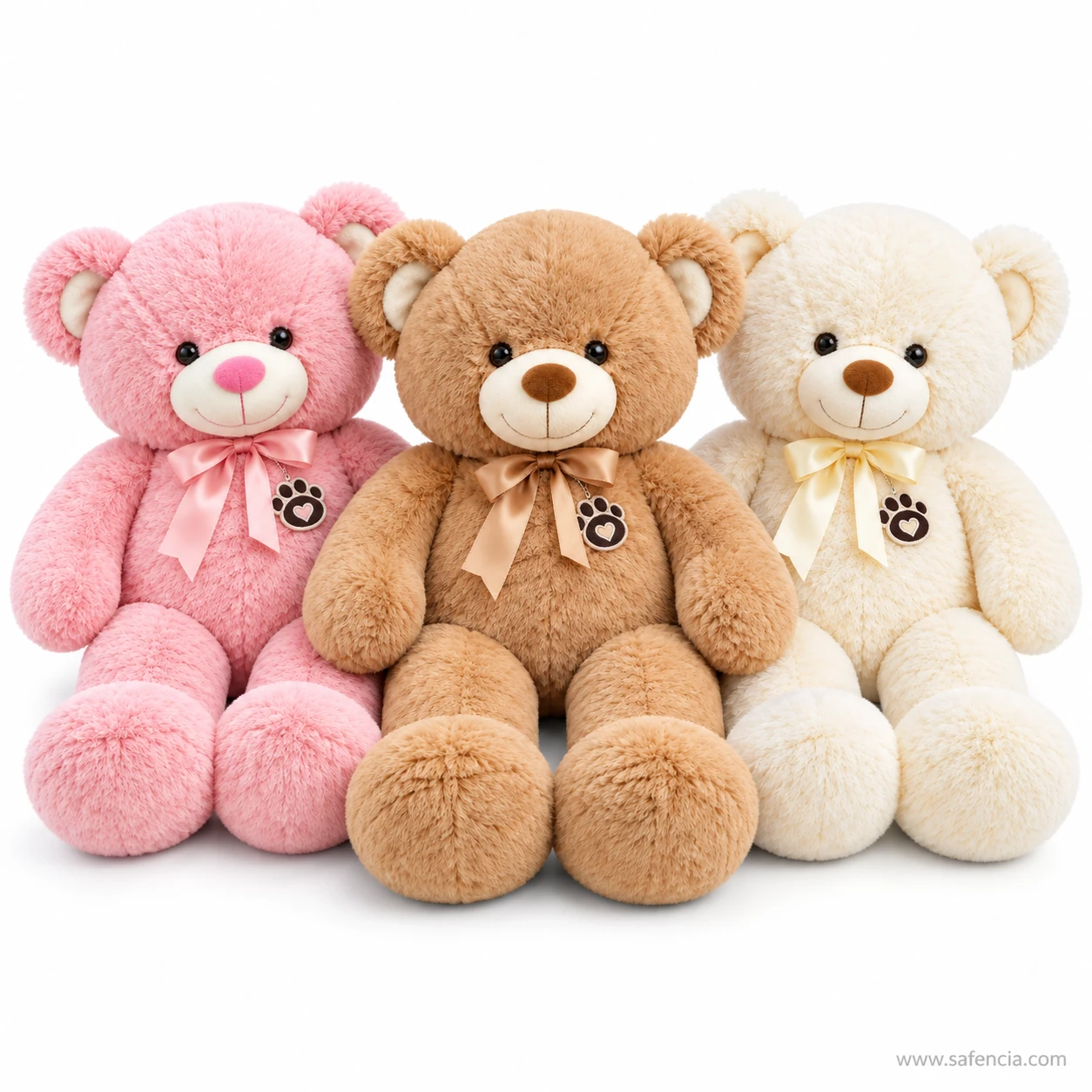 Three ribbon teddy bears in pink, light brown and cream sitting in a row with satin bows