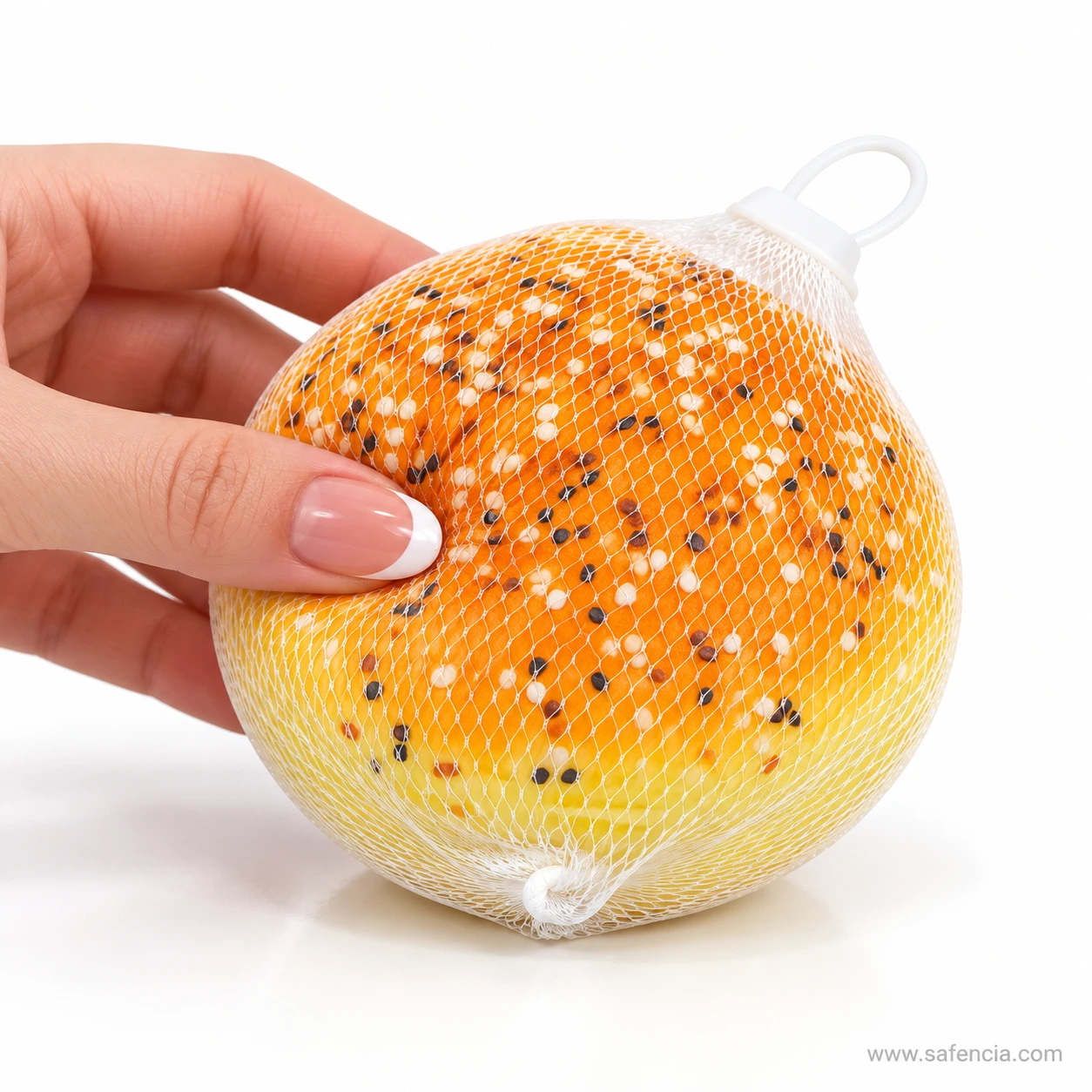 Fingertips pressing into the top of the sesame bun squishy through its white mesh net