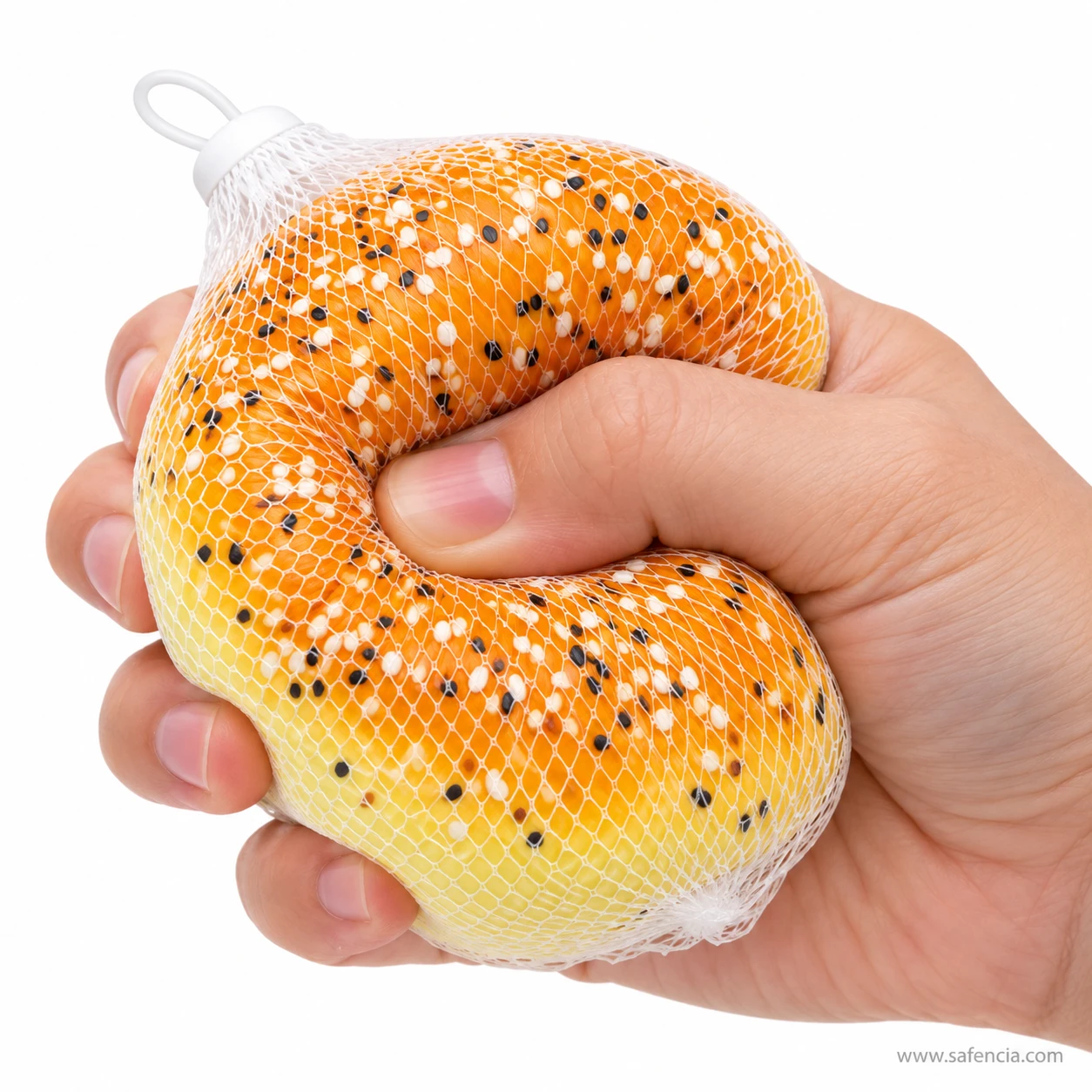 Hand squeezing the sesame bun squishy through its mesh net so the bun folds deeply