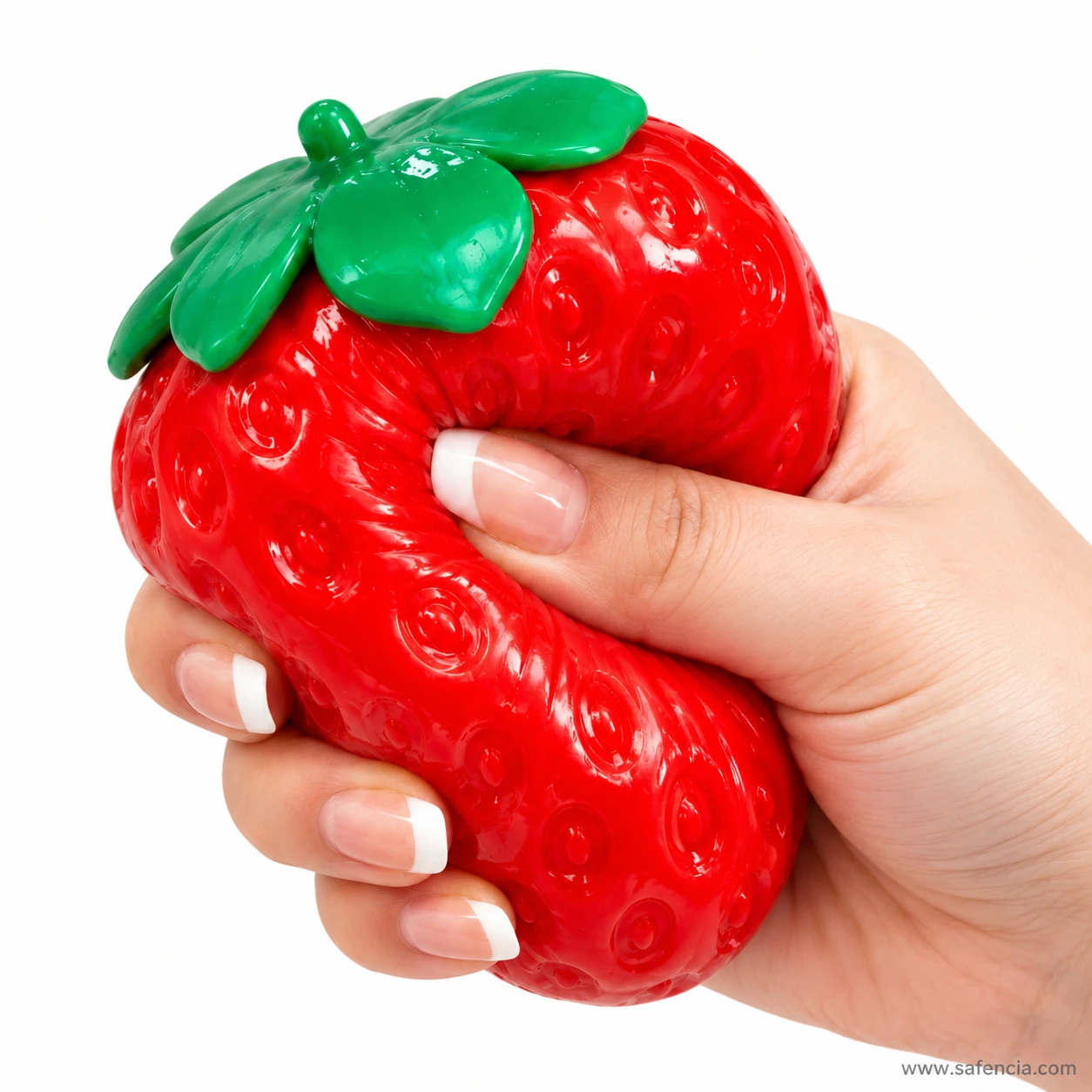 Close view of fingers pressing into the glossy strawberry squishy, stretching the seed dimples apart