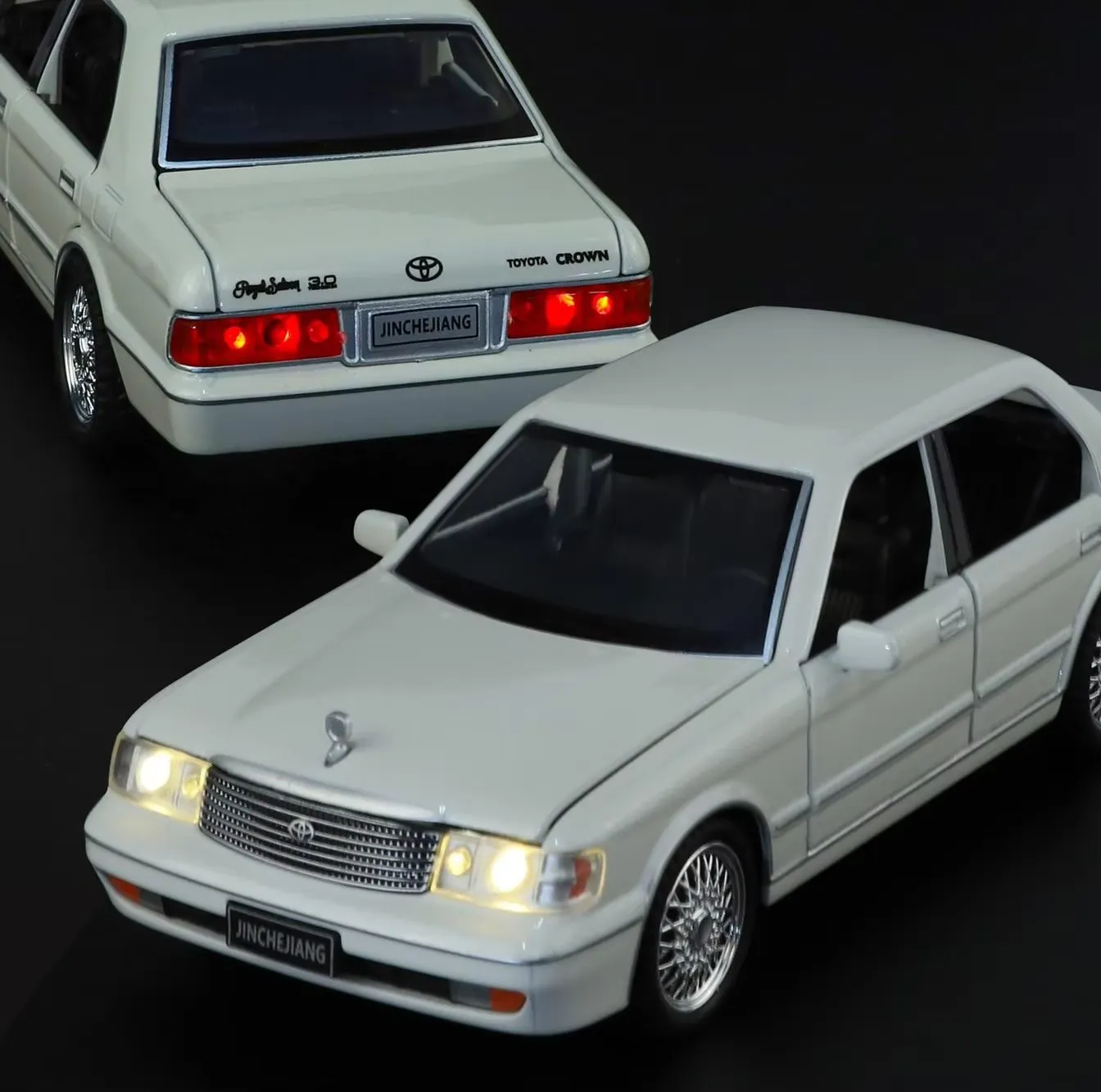 White 1987 Toyota Crown S130 diecast model with headlights and tail lights lit