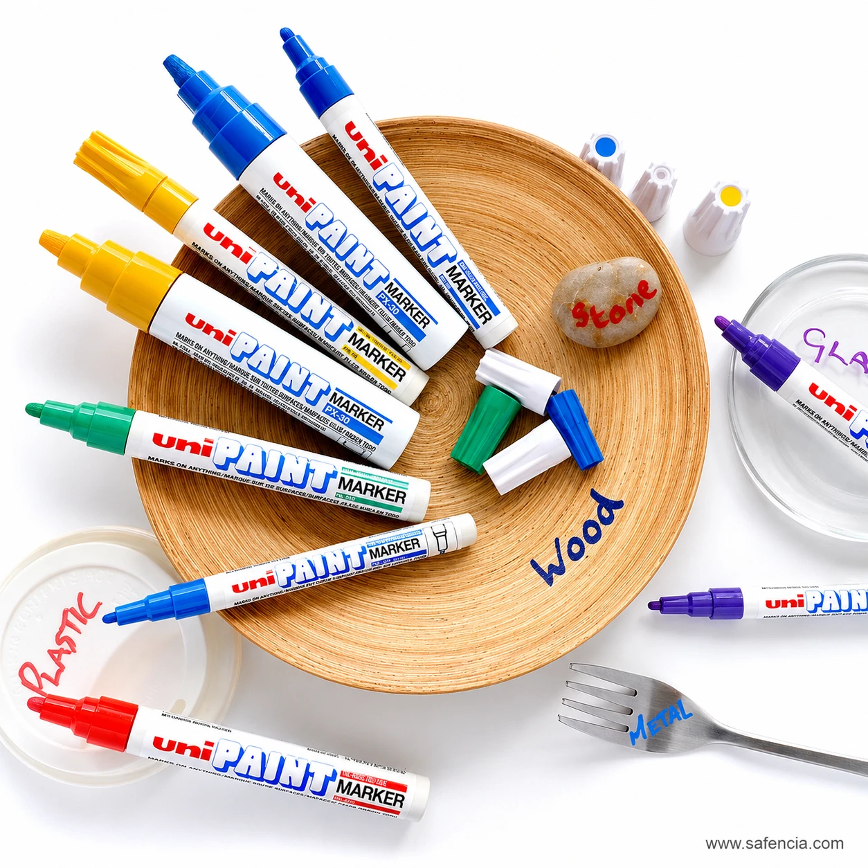 Uni paint markers arranged with wood, stone, glass and plastic samples