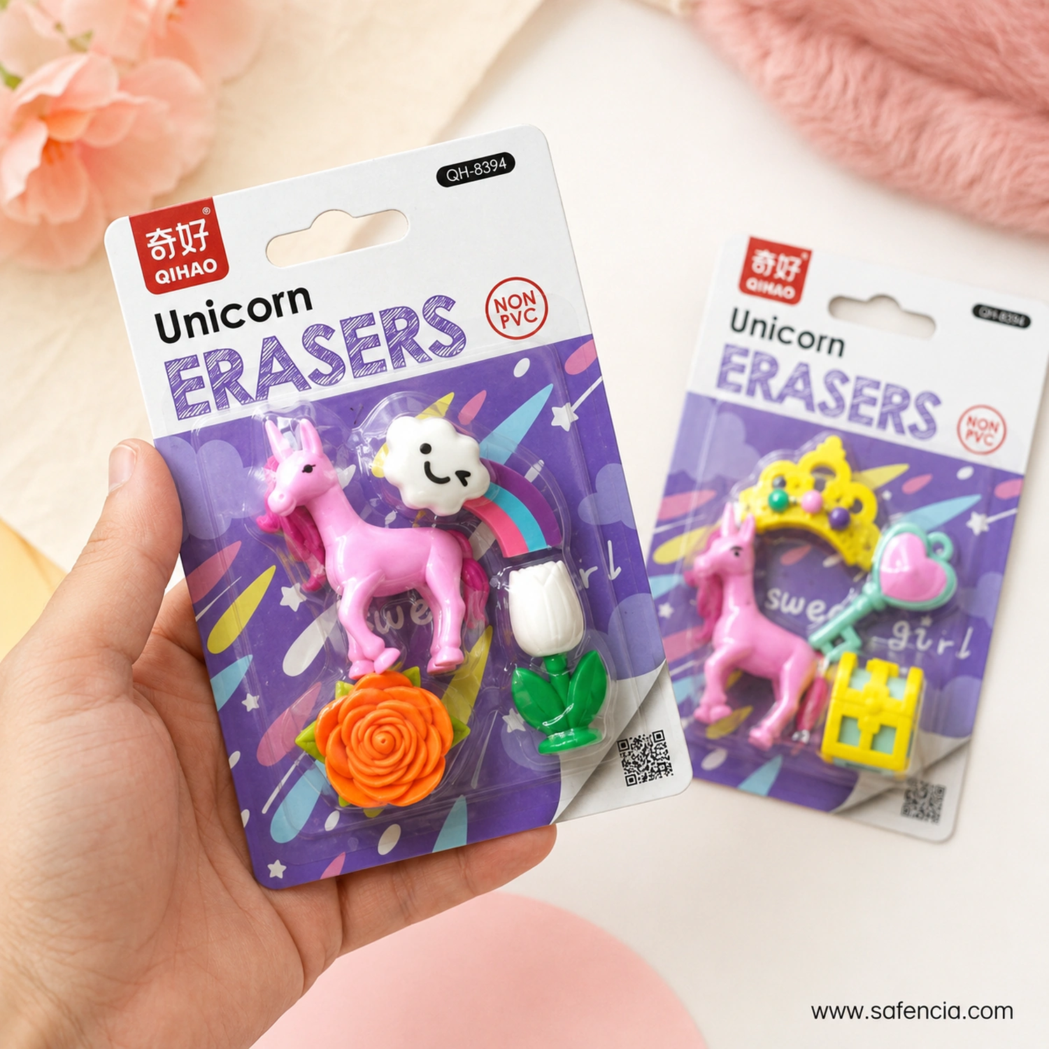 Hand holding the garden variant unicorn eraser card, showing the palm-size scale with the princess variant beside it