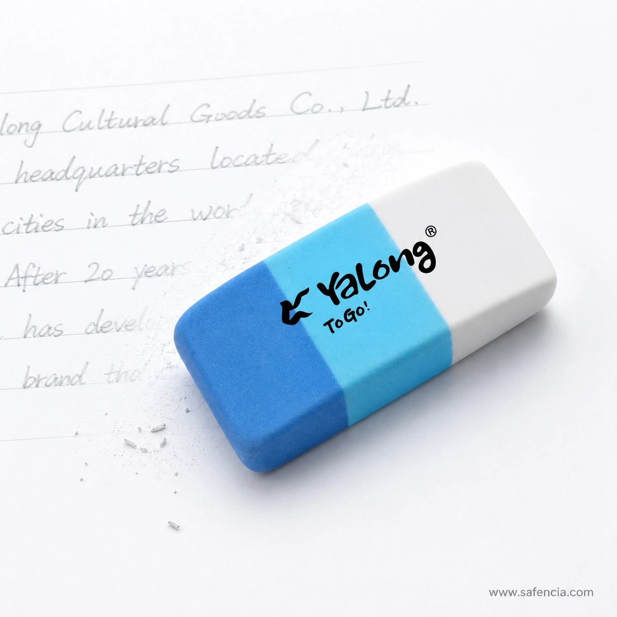 Blue Yalong Y221535 eraser resting on a notebook page beside erased pencil handwriting and loose eraser crumbs